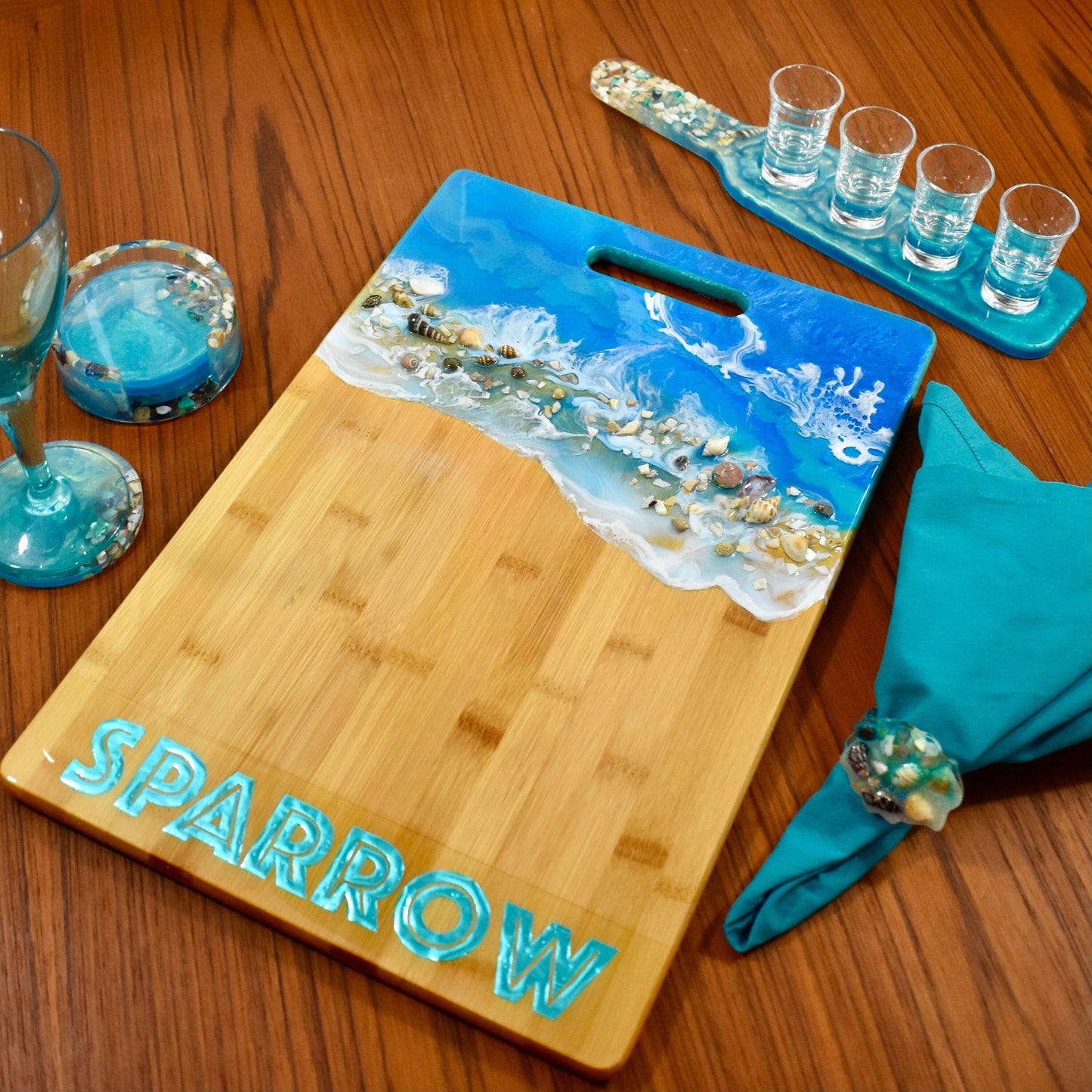 This beach-themed personalized charcuterie board makes a fabulous gift set with matching beverage coasters, shot glass paddle, and napkin rings!