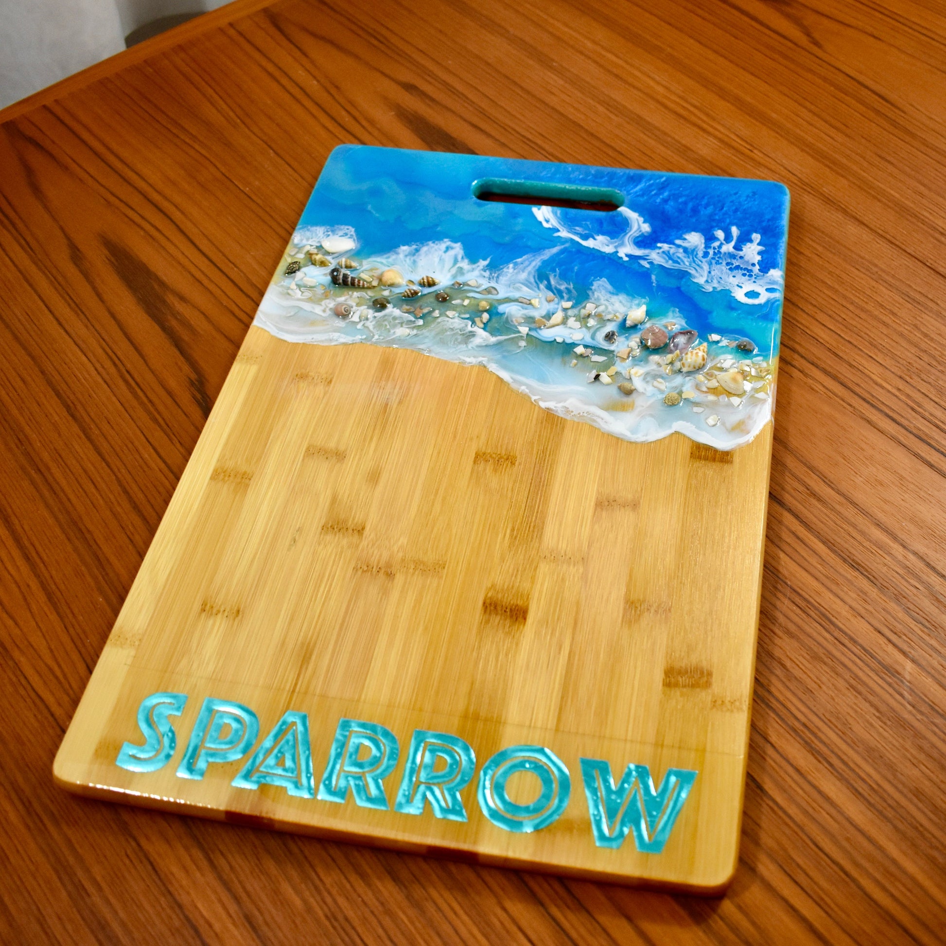 This beach-themed charcuterie board is personalized with the name "Sparrow."